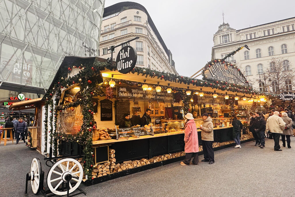 People at a food stall at the Vörösmarty Square Christmas Market in Budapest, Hungary.