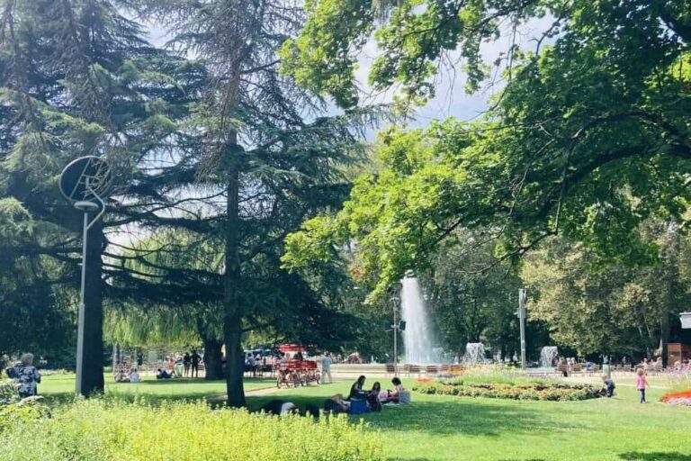 People sitting in a park on Margaret Island, Budapest.