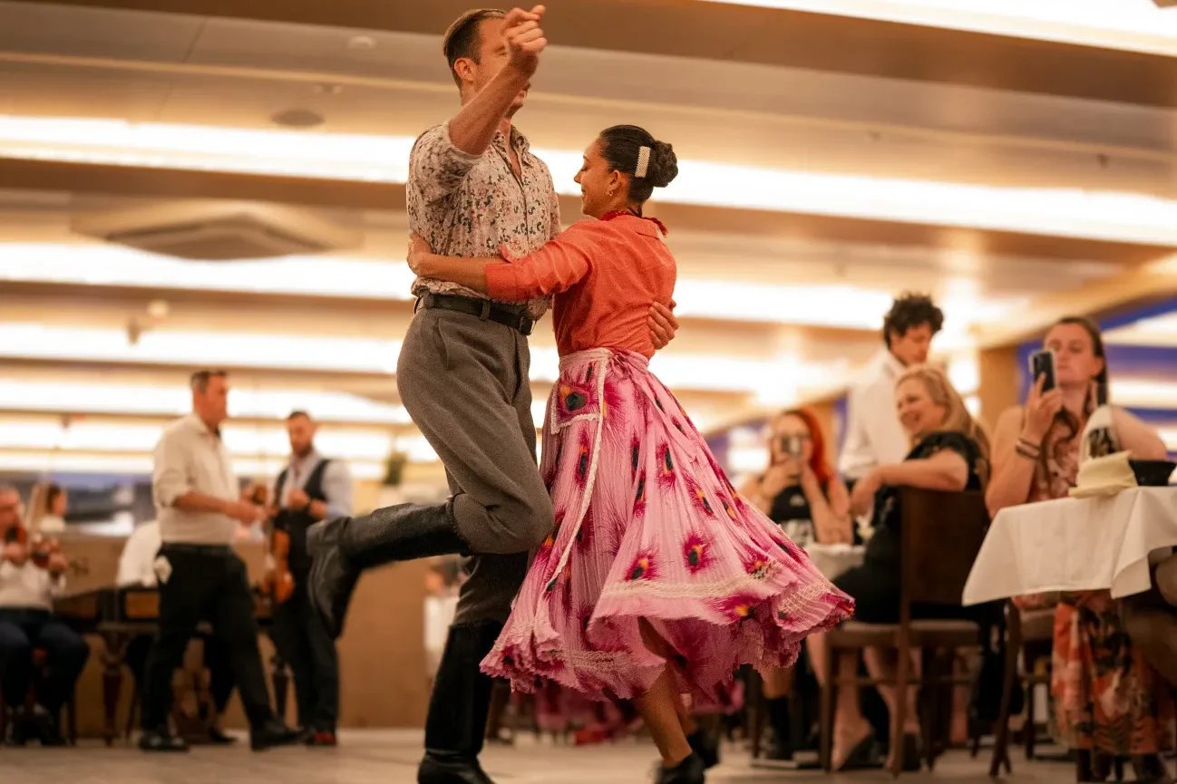 Artists performing a traditional Hungarian folk dance on a dinner cruise in Budapest.