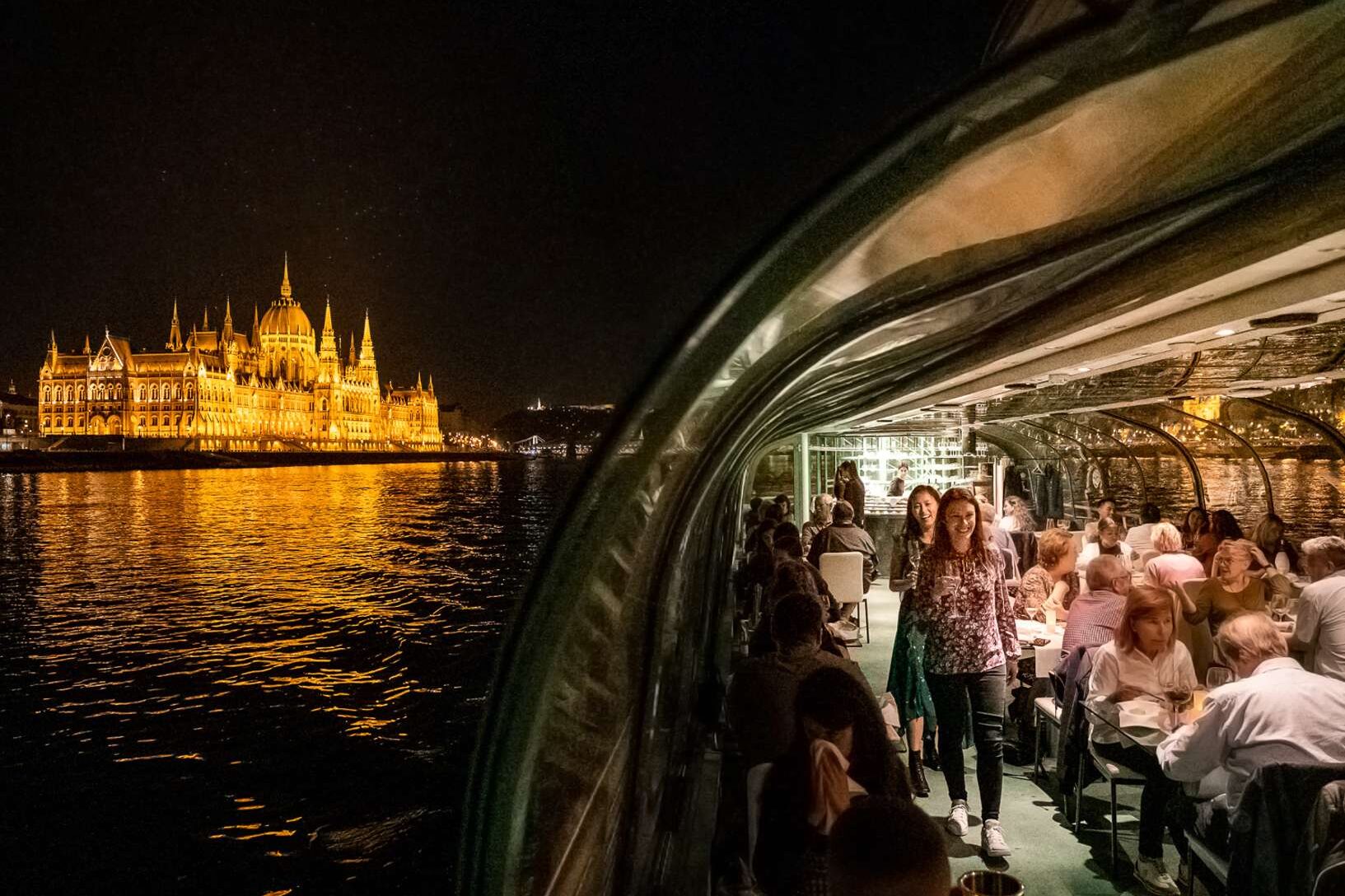 People on the Legenda cruise ship in Budapest with the Parliament in the background.