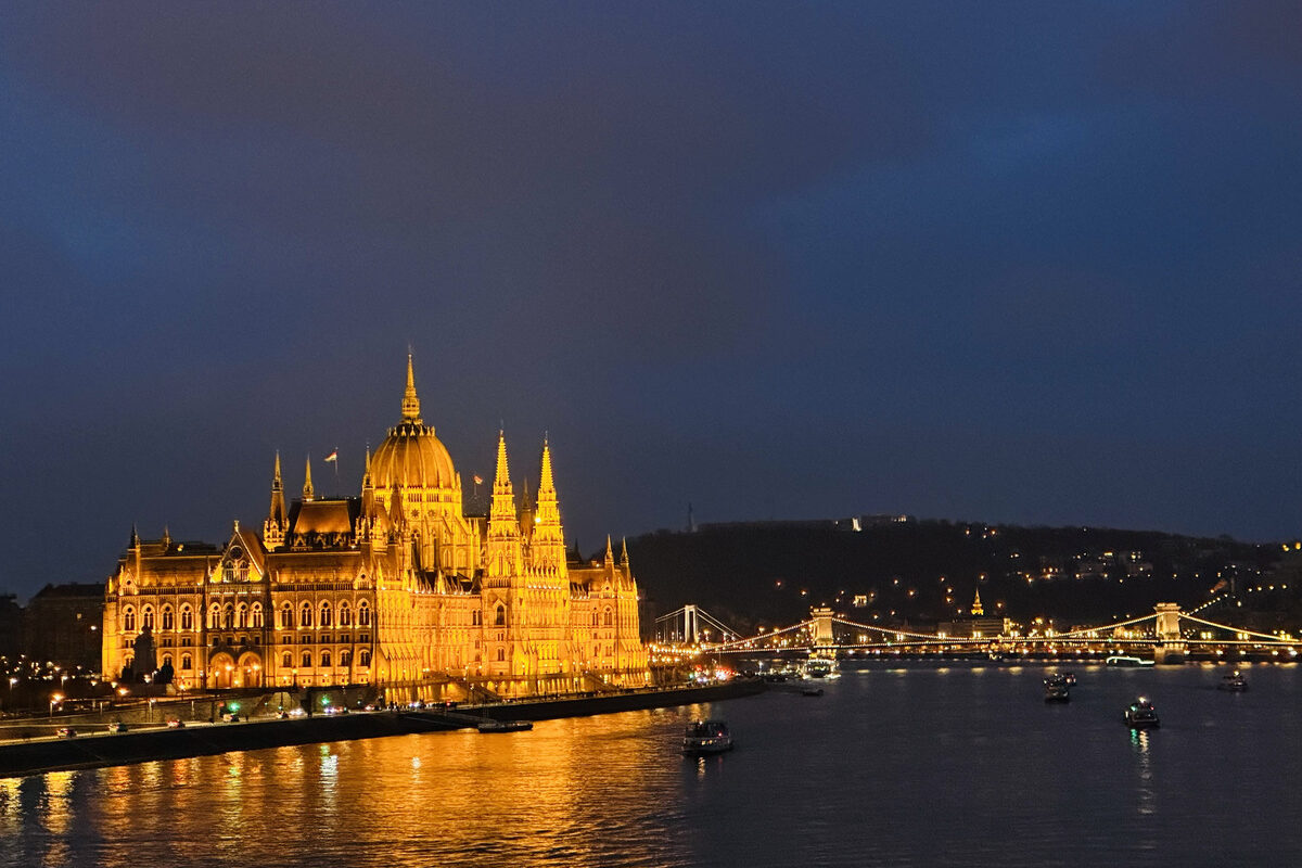 A boat on the River Danube in the evening with the Parliament in the background.