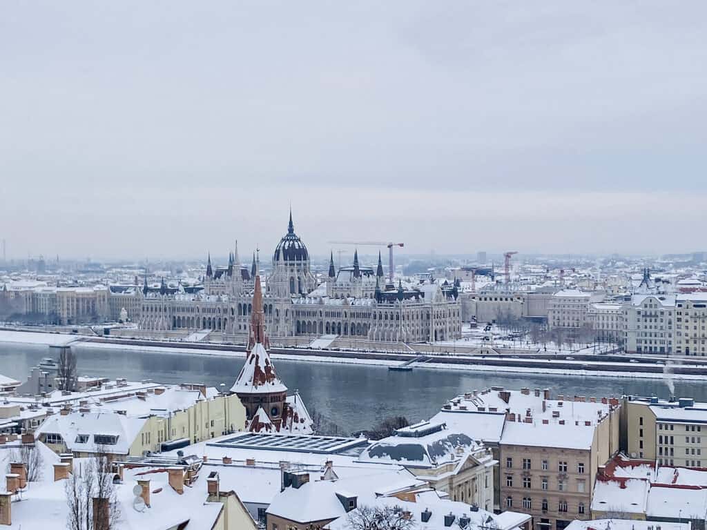 View of the Parliament and houses with snow on their rooftops from the Fisherman's Bastion in Budapest, Hungary.