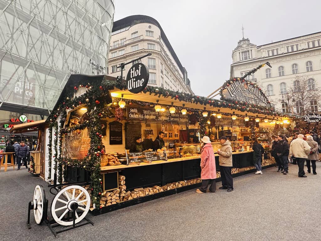 People at a food stall at the Vörösmarty Square Christmas Market in Budapest, Hungary.